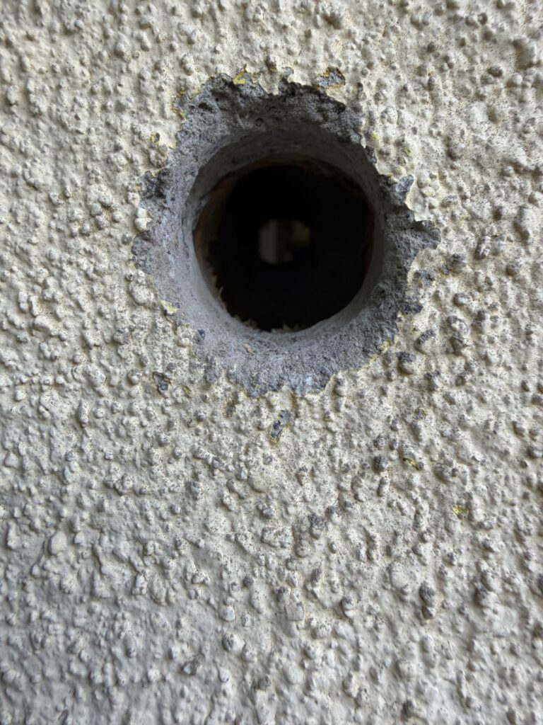 【画像：穴の断面。表面の下にグレーのモルタル層が見える（IMG_6551.jpeg）】
